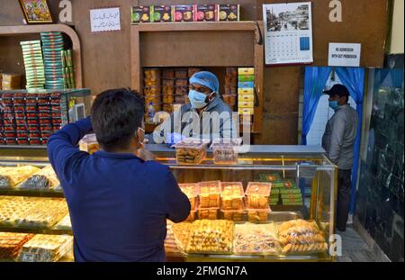 Srinagar, Inde. 09e mai 2021. Un résident fait ses courses dans une boulangerie avant le festival musulman Eid al-Fitr lors d'un confinement imposé par les autorités suite à l'augmentation des cas de coronavirus à Srinagar. Alors que le mortel Covid-19 continue de menacer la vallée, les autorités ont prolongé dimanche le confinement actuel du COVID-19 devant le festival musulman Eid al-Fitr. Crédit : SOPA Images Limited/Alamy Live News Banque D'Images