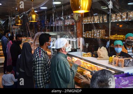 Srinagar, Inde. 09e mai 2021. Les résidents portant des masques faciaux font leurs courses dans une boulangerie avant le festival musulman Eid al-Fitr lors d'un confinement imposé par les autorités suite à l'augmentation des cas de coronavirus à Srinagar. Alors que le mortel Covid-19 continue de menacer la vallée, les autorités ont prolongé dimanche le confinement actuel du COVID-19 devant le festival musulman Eid al-Fitr. (Photo de Saqib Majeed/SOPA Images/Sipa USA) crédit: SIPA USA/Alay Live News Banque D'Images