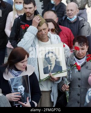 Kiev, Ukraine. 09e mai 2021. Les gens sont vus porter des portraits d'anciens combattants de la Seconde Guerre mondiale alors qu'ils lataient des fleurs au monument du Soldat inconnu marquant le jour de la victoire et le 76e anniversaire de la victoire sur l'Allemagne nazie dans la deuxième Guerre mondiale, à Kiev. Crédit : SOPA Images Limited/Alamy Live News Banque D'Images