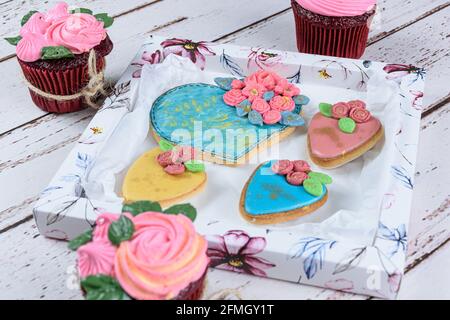 Biscuit au beurre, décoré de fondant et de glaçage royal. Entouré de petits gâteaux et de biscuits. Banque D'Images