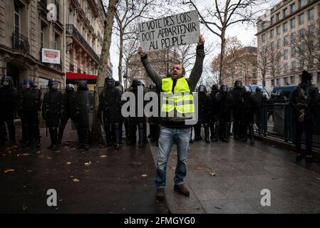 Un manifestant tient un écriteau qui lit "le vote de la loi doit appartenir au peuple", près de l'Arc de Triomphe pendant le quatrième samedi de la rp nationale Banque D'Images