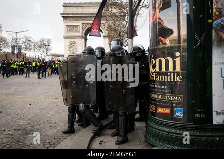 Les policiers sont garde à l'avenue des champs-Élysées, près de la Arc de Triomphe pendant le quatrième samedi des manifestations nationales par les gilets jaunes Banque D'Images