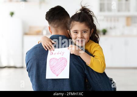 Adorable petite fille arabe saluant papa avec la Journée internationale des pères, carte de présentation Banque D'Images