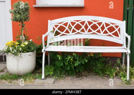 Banc blanc et plante en pot devant une maison Banque D'Images