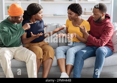 Deux couples afro-américains se battent, à l'intérieur de leur maison Banque D'Images
