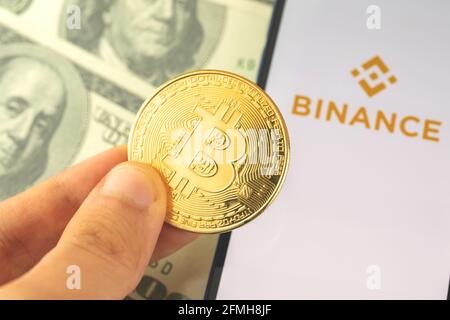 Kharkov, Ukraine - 3 mai 2021 : application bitcoin Binance à l'écran, pièce en main, logo de l'application pour acheter et vendre cryptocurency Banque D'Images