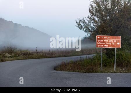 Spruce Knob Lake Road en Virginie-Occidentale le matin avec signez les directions et brumisez le givre et les arbres de forêt dans automne saison d'automne vue sur le paysage Banque D'Images