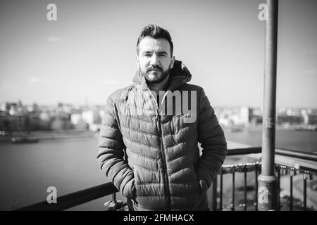 Prise de vue en niveaux de gris d'un jeune homme posant dans un Bateau par temps froid en Bosnie-Herzégovine Banque D'Images