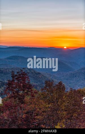 Vue verticale aérienne à grand angle sur la Virginie-Occidentale Monongahela National forêt avec soleil derrière les montagnes, vue en automne avec coloré feuillage d'arbre a Banque D'Images