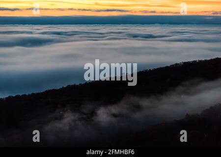 Vue aérienne à grand angle au-dessus des nuages d'inversion au lever du soleil matin à Wintergreen Resort, ville de ski de Virginie avec ciel coloré et arbres d'automne dans Blue R Banque D'Images