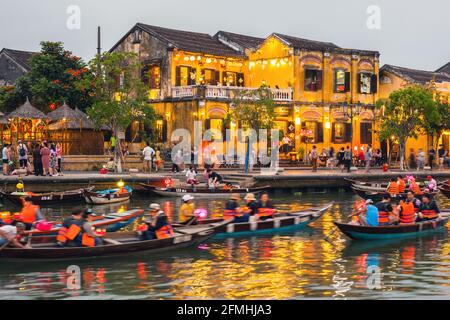 Des lumières colorées se reflètent sur l'eau tandis que les bateaux parcourent la rivière dans la vieille ville, Hoi an, Vietnam Banque D'Images