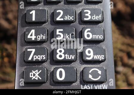 Un gros plan des chiffres sur le noir sale vieux Télécommande du téléviseur Banque D'Images
