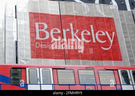 Une propriété de Berkeley à Marsh Wall, à l'est de Londres avec un train DLR passant devant la gare de South Quay Banque D'Images