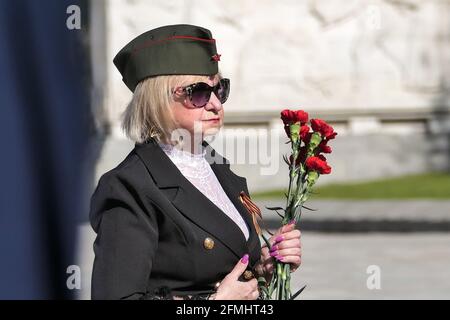 Berlin, Allemagne. 9 mai 2021. Une femme vient déposer des fleurs au Mémorial soviétique de Treptower Park lors d'un rassemblement pour marquer le 76e anniversaire de la fin de la Seconde Guerre mondiale en Europe, connue sous le nom de victoire en Europe Day, à Berlin, capitale de l'Allemagne, le 9 mai 2021. Credit: Stefan Zeitz/Xinhua/Alay Live News Banque D'Images