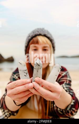 Artisanale créative montrant une collection de pierres semi-précieuses blanches à caméra sur fond de mer Banque D'Images