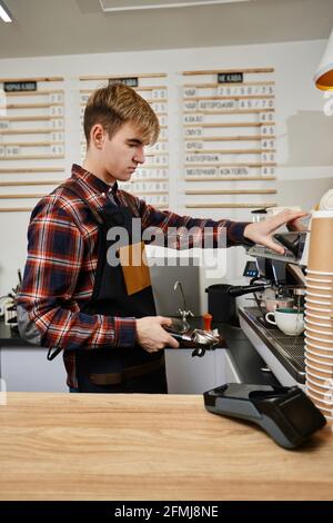 Le barista utilise une machine à café pour préparer le café Banque D'Images