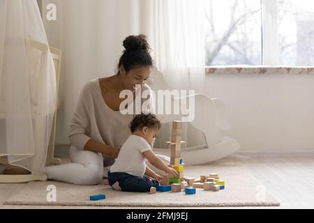 Une maman afro-américaine aimante joue avec une petite fille Banque D'Images