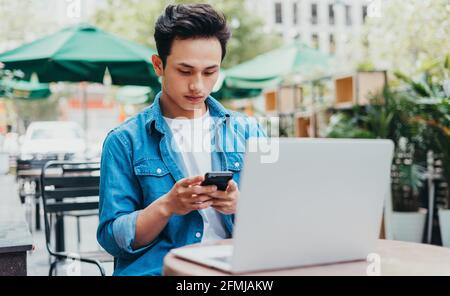 Jeune asiatique travaillant au café Banque D'Images