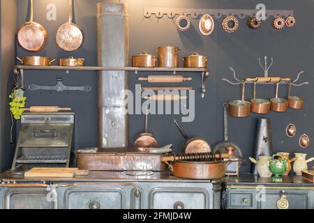 Casseroles et poêles en cuivre et autres ustensiles de cuisine dans une cuisine en métal antique. Banque D'Images