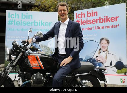 Solingen, Allemagne. 10 mai 2021. Hendrik Wüst (CDU), ministre des Transports de la Rhénanie-du-Nord-Westphalie, est assis devant des affiches de la campagne publicitaire "Je suis #leiserbiker" sur une moto. Sous le slogan 'I am #leiserbiker. Runter!Lärm runter!' Une initiative contre le bruit de la moto est lancée en NRW. 150 affiches à grande échelle sont prévues dans toute la Rhénanie-du-Nord-Westphalie. Credit: Oliver Berg/dpa/Alay Live News Banque D'Images