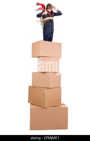 Homme d'affaires avec une fusée et des friandises maison sur une pile de boîtes en carton, prêt à enlever Banque D'Images