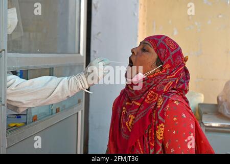 Beawar, Rajasthan, Inde, 10 mai 2021 : un agent de santé recueille un échantillon d'écouvillonnage auprès d'une femme du village dans un laboratoire de test COVID-19 pendant la deuxième vague d'épidémie de coronavirus, à Beawar. Lundi, le ministère de la Santé a signalé 366,161 nouvelles infections et 3,754 décès. Le nombre d’infections en Inde s’élève aujourd’hui à 22.66 millions, dont 246,116 000 morts. 80 médecins de l'hôpital Saroj de Delhi ont été testés positifs pour le coronavirus. Crédit : Sumit Saraswat/Alay Live News Banque D'Images