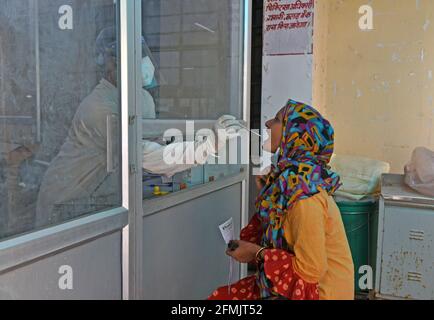 Beawar, Rajasthan, Inde, 10 mai 2021 : un agent de santé recueille un échantillon d'écouvillonnage auprès d'une jeune femme dans un laboratoire de test COVID-19 pendant la deuxième vague d'épidémie de coronavirus, à Beawar. Lundi, le ministère de la Santé a signalé 366,161 nouvelles infections et 3,754 décès. Le nombre d’infections en Inde s’élève aujourd’hui à 22.66 millions, dont 246,116 000 morts. 80 médecins de l'hôpital Saroj de Delhi ont été testés positifs pour le coronavirus. Crédit : Sumit Saraswat/Alay Live News Banque D'Images