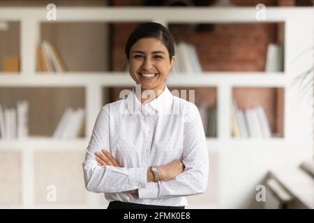 Portrait en tête souriant femme d'affaires indienne avec les bras croisés Banque D'Images