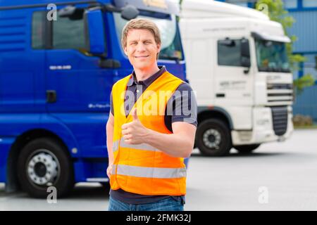 Logistique - fier conducteur ou le transitaire à l'avant des camions et remorques, sur un point de transbordement Banque D'Images