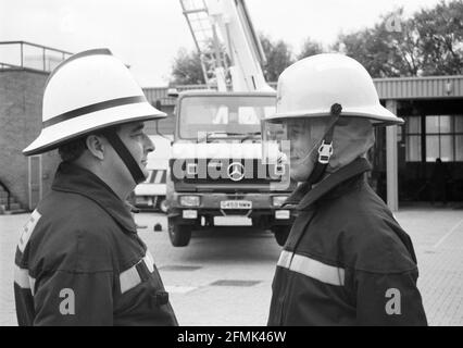 Nouveau v ancien style de casque de pompier. Le nouveau casque, à droite, est dévoilé à la caserne de pompiers de Salisbury, dans le Wiltshire, en 1990. Banque D'Images