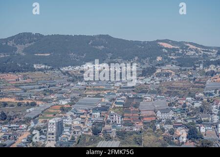 Paysage panoramique, ville de Dalat, plateau de Langbian, région des Highlands du centre du Vietnam. Champs de légumes, nombreuses maisons, architecture, terres agricoles, serre Banque D'Images