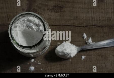 bicarbonate de soude, multi-usages ou poudre à lever. Vue d'en haut sur fond de bois. Sur une cuillère dans un pot en verre Banque D'Images