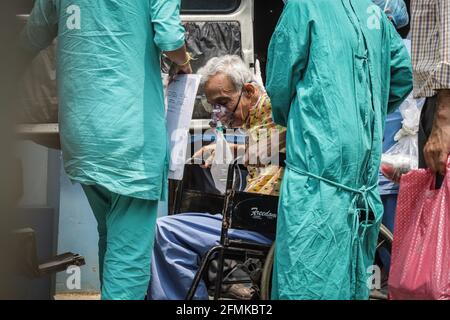 Un patient âgé dont le test de dépistage de COVID-19 est positif est conduit à un hôpital de soins COVID-19 tout en portant un masque à oxygène car il ressent un essoufflement. Crédit : SOPA Images Limited/Alamy Live News Banque D'Images