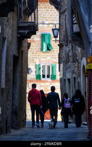 Rue étroite typique de la ville de Pienza en Toscane, Italie. Un groupe de personnes se promène dans la rue Banque D'Images