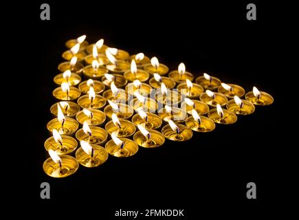 Triangle fait de bougies allumées la nuit Banque D'Images