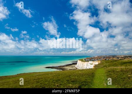 La vue vers Peacehaven, Sussex Royaume-Uni depuis les hauteurs de Newhaven à marée basse lors d'une journée d'été ensoleillée avec des cumulus dans le ciel. Banque D'Images