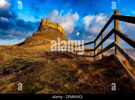 Un sentier sinueux mène jusqu'au château de Lindisfarne, sur l'île Sainte, dans le Northumberland Banque D'Images