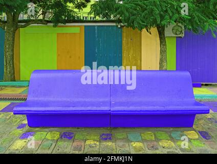 Banc de béton vide bleu cobalt vif style pop art avec mur en bois multicolore en arrière-plan Banque D'Images