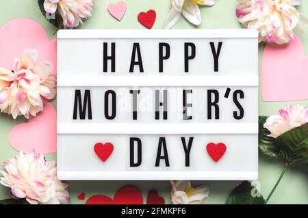 Happy Mother's Day.Lightbox avec le mot Happy Mother's Day Next aux coeurs et aux fleurs sur fond vert Banque D'Images