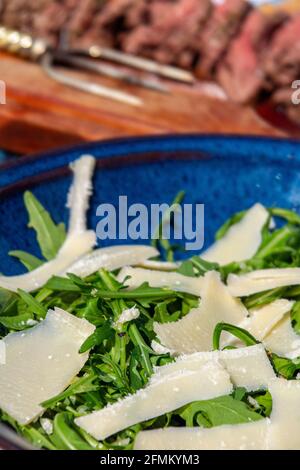 Un délicieux déjeuner en plein air composé de plats de bœuf rares et salade de parmesan et de roquette Banque D'Images