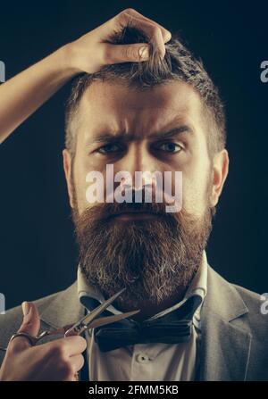 Homme barbu, longue barbe, brutal, casien hippster avec moustache, coupe de cheveux. Barbershop vintage, rasage. Coupe de cheveux pour hommes. Ciseaux de barbier. Beau Banque D'Images