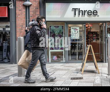 Belfast, Royaume-Uni. 09e mai 2021. Un client utilisant un téléphone mobile a vu passer devant la boutique de téléphones mobiles Three. (Photo de M. Mc Nerney/SOPA Images/Sipa USA) crédit: SIPA USA/Alay Live News Banque D'Images