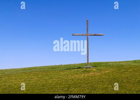 grand symbole chrétien en bois sur une colline ou une colline herbeuse rurale comme un paysage de la nature de fond religieux Banque D'Images