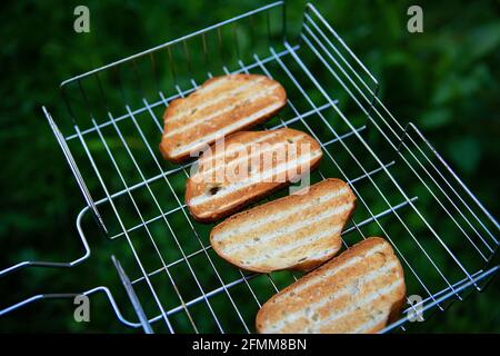 Grille-pain croustillante grillée sur la grille métallique. Activités de plein air. Feu de camp, barbecue, délicieux. Vue de dessus Banque D'Images