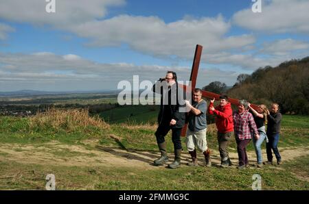 Porter une croix en bois sur Cam Peak le Vendredi Saint avant le dimanche de Pâques dans une promenade de témoin, Gloucestershire Banque D'Images