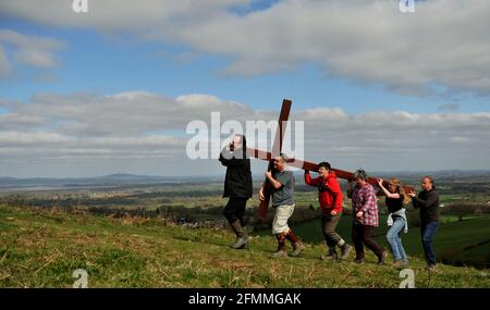 Porter une croix en bois sur Cam Peak le Vendredi Saint avant le dimanche de Pâques dans une promenade de témoin, Gloucestershire Banque D'Images