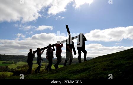 Porter une croix en bois sur Cam Peak le Vendredi Saint avant le dimanche de Pâques dans une promenade de témoin, Gloucestershire Banque D'Images