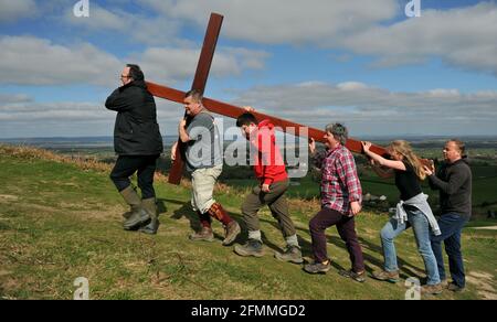 Porter une croix en bois sur Cam Peak le Vendredi Saint avant le dimanche de Pâques dans une promenade de témoin, Gloucestershire Banque D'Images