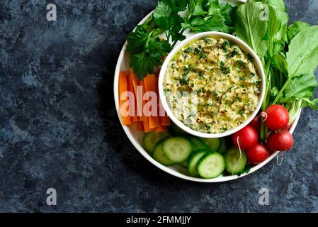 Vue rapprochée de baba ganoush (trempette d'aubergines rôties) dans un bol sur fond de pierre bleue avec espace de texte libre. Une alimentation saine. Cuisine végétarienne co Banque D'Images