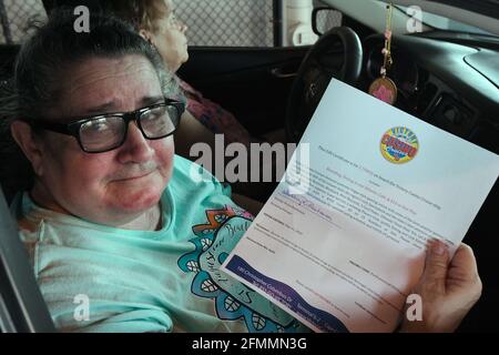 Port Canaveral, États-Unis. 10 mai 2021. CAREN Stewart présente un bon pour une croisière Victory Casino pour deux personnes qu'elle a reçu pour avoir reçu un coup de feu lors d'un trajet à travers la clinique de vaccination COVID-19 pour les employés de Port Canaveral, les travailleurs des hôtels et restaurants locaux, et les résidents de la communauté de Port Canaveral. Les 200 premières personnes qui ont été vaccinées ont reçu des bons de croisière de casino alors que la demande américaine pour le vaccin diminue. Crédit : SOPA Images Limited/Alamy Live News Banque D'Images